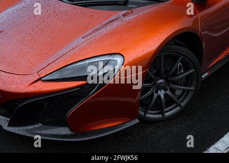 La ruota in lega grigio satinato anteriore e il faro anteriore allo xeno Di UN Vulcano Orange 2015 McLaren 650S Coupe Supercar Foto Stock