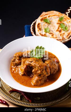 Concetto di cibo casalingo di manzo masala curry e roti paratha on asse di legno con spazio per la copia Foto Stock