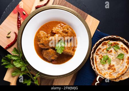 Concetto di cibo casalingo di manzo masala curry e roti paratha on asse di legno con spazio per la copia Foto Stock