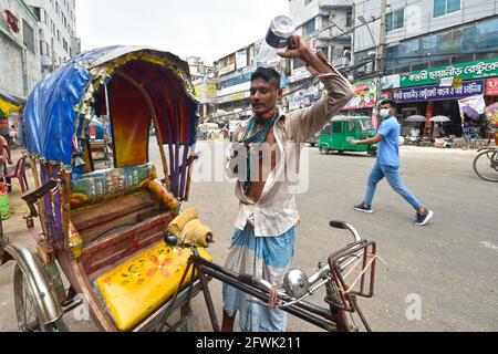 Dhaka. 23 maggio 2021. Un estrattore di risciò versa acqua sulla testa durante il tempo caldo a Dhaka, Bangladesh il 23 maggio 2021. Credit: Sr/Xinhua/Alamy Live News Foto Stock