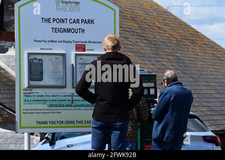 Costo del parcheggio nel Regno Unito per Teignmouth South Devon. La gente è vista pagare con la carta di credito in macchina in piedi nel parcheggio auto, e un tabellone display barrido Foto Stock