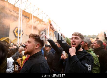 I fan di Wolverhampton Wanderers sfuggono al fumo che si trova fuori dallo stadio prima della partita della Premier League al Molineux Stadium, Wolverhampton. Data immagine: Domenica 23 maggio 2021. Foto Stock