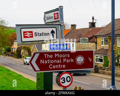 Cartello nel centro del villaggio di Danby che mostra la direzione per il Stazione ferroviaria la pista ciclabile per Castleton e per il Moors National Park Centre Foto Stock