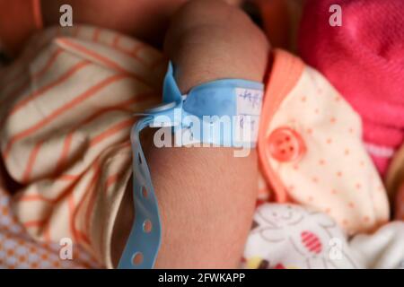 Mano del neonato con un braccialetto sul polso Foto Stock