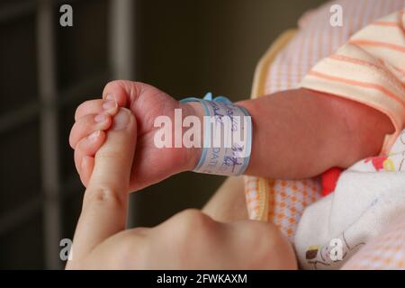 Bambino che tiene il dito della madre, neonato che tiene la mano della madre Foto Stock