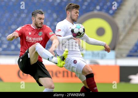 Hannover, Germania. 23 maggio 2021. Calcio: 2. Bundesliga, Hannover 96 - 1. FC Nürnberg, Matchday 34 all'HDI Arena. Josip Elez (l) di Hannover combatte per la palla con Erik Shuranov di Nürnberg. Credit: Hauke-Christian Dittrich/dpa - NOTA IMPORTANTE: In conformità con le norme del DFL Deutsche Fußball Liga e/o del DFB Deutscher Fußball-Bund, è vietato utilizzare o utilizzare fotografie scattate nello stadio e/o della partita sotto forma di sequenze fotografiche e/o serie fotografiche di tipo video./dpa/Alamy Live News Foto Stock