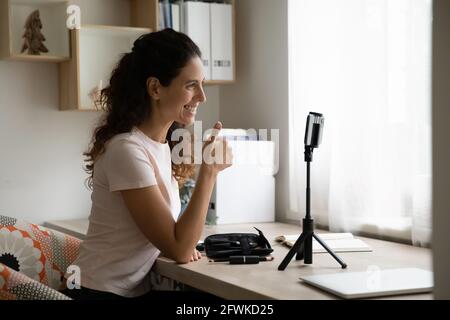 Sorridente blogger ispanica femminile godendo di attività vlogging. Foto Stock