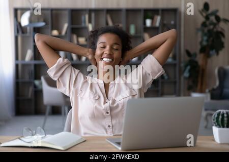 Felice millenaria donna di etnia africana che riposa dopo una dura giornata lavorativa. Foto Stock