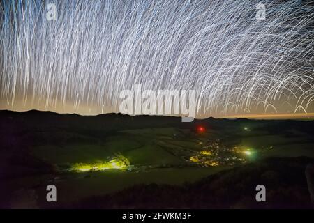 Tracce insolite di stelle durante la rotazione e l'esposizione prolungata il paesaggio notturno Foto Stock