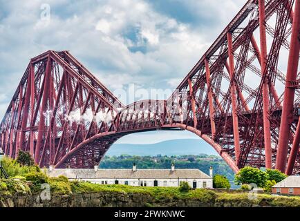 Volando sul treno a vapore Scotsman si attraversa l'iconico Forth Rail Bridge verso Fife visto dal North Queensferry, Scozia, Regno Unito Foto Stock