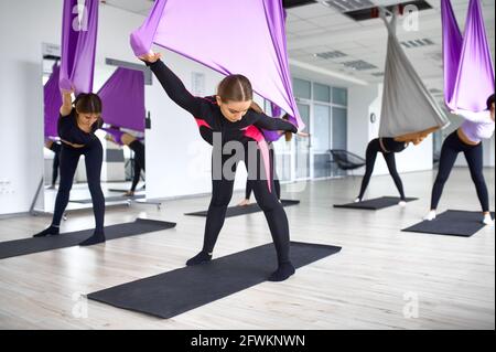 Yoga di mosca, formazione di gruppo femminile con amache. Fitness, pilates e  esercizi di danza mix. Donne in allenamento yoga in studio sportivo Foto  stock - Alamy