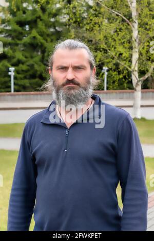 Un uomo di 50 anni con una barba grigia. Giorno, scatto orizzontale Vista frontale. Surgut, Russia - 17 maggio 2021. Foto Stock