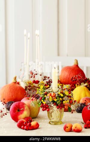 Portacandele d'autunno decorato con rosa, bacche di biancospino e tansy. Decorazioni per feste Foto Stock