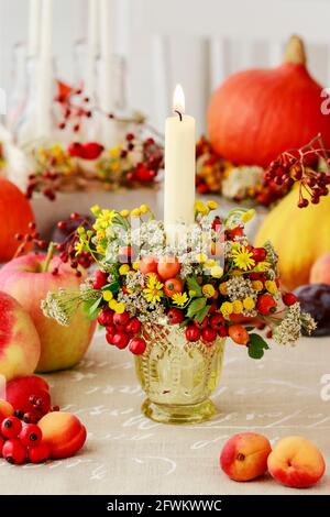 Portacandele d'autunno decorato con rosa, bacche di biancospino e tansy. Decorazioni per feste Foto Stock