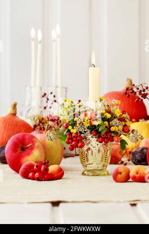 Portacandele d'autunno decorato con rosa, bacche di biancospino e tansy. Decorazioni per feste Foto Stock