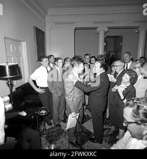 L'attore e comico, Bob Hope, si reca in visita con il comico Milton Berle, dopo la cerimonia di presentazione della medaglia d'oro al Congresso di Hope; ha ricevuto la medaglia dal presidente John F. Kennedy in riconoscimento dei suoi servizi nel paese come intrattenitore durante la seconda guerra mondiale I giornalisti osservano, compreso il corrispondente della Casa Bianca per United Press International (UPI), Helen Thomas (in piedi al centro, tra il Sig. Berle e il Sig. Hope), e il corrispondente della Casa Bianca per la Washington Star, Garnett D. Horner (in piedi a destra, dietro il Sig. Hope). Foto Stock
