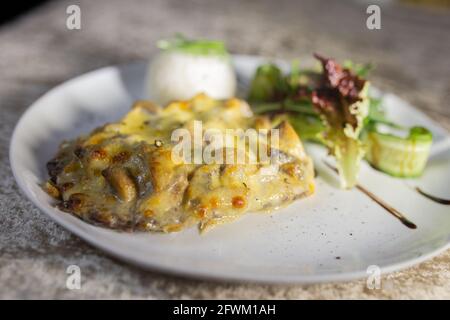 casseruola di funghi con riso ed erbe su un piatto bianco. Foto Stock