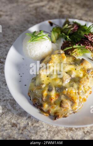 casseruola di funghi con riso ed erbe su un piatto bianco. Foto Stock