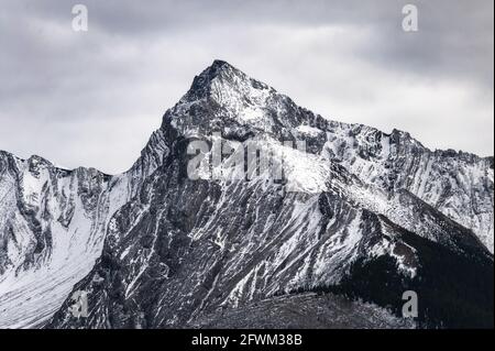 Grande vetta di montagna con neve coperta e cielo coperto Canada Foto Stock