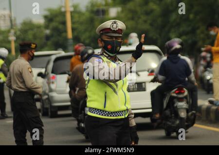 Madiun, Indonesia. 23 maggio 2021. Personale della polizia di Madiun durante il controllo di veicoli con targhe all'esterno e all'interno dell'area della reggenza di Madiun. Questa attività è nel contesto di una campagna per prevenire il virus corona o covid-19 socializzando il protocollo sanitario 5M, vale a dire lavarsi le mani con sapone con acqua corrente, indossare maschere, mantenere la distanza, limitare la mobilità e stare lontano dalla folla. (Foto di Ajun Ally/Pacific Press) Credit: Pacific Press Media Production Corp./Alamy Live News Foto Stock