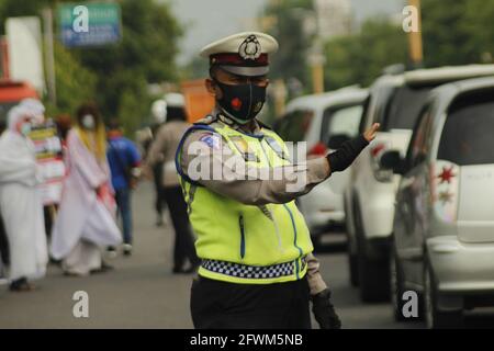 Madiun, Indonesia. 23 maggio 2021. Personale della polizia di Madiun durante il controllo di veicoli con targhe all'esterno e all'interno dell'area della reggenza di Madiun. Questa attività è nel contesto di una campagna per prevenire il virus corona o covid-19 socializzando il protocollo sanitario 5M, vale a dire lavarsi le mani con sapone con acqua corrente, indossare maschere, mantenere la distanza, limitare la mobilità e stare lontano dalla folla. (Foto di Ajun Ally/Pacific Press) Credit: Pacific Press Media Production Corp./Alamy Live News Foto Stock