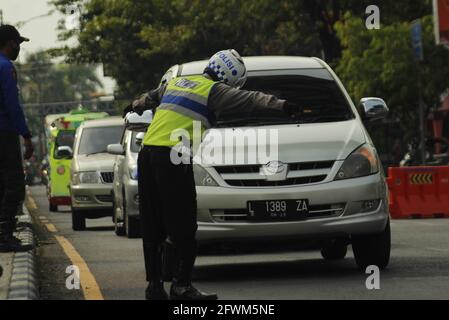 Madiun, Indonesia. 23 maggio 2021. Personale della polizia di Madiun durante il controllo di veicoli con targhe all'esterno e all'interno dell'area della reggenza di Madiun. Questa attività è nel contesto di una campagna per prevenire il virus corona o covid-19 socializzando il protocollo sanitario 5M, vale a dire lavarsi le mani con sapone con acqua corrente, indossare maschere, mantenere la distanza, limitare la mobilità e stare lontano dalla folla. (Foto di Ajun Ally/Pacific Press) Credit: Pacific Press Media Production Corp./Alamy Live News Foto Stock