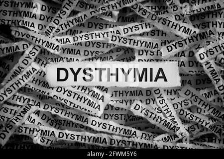 Distimia. Strappato pezzi di carta con le parole Dythymia. Immagine in bianco e nero. Primo piano. Foto Stock