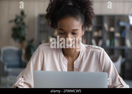 Felice giovane afroamericana che lavora al computer. Foto Stock