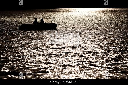 Hannover, Germania. 23 maggio 2021. Una coppia guida un pedalò attraverso il Maschsee alla luce del sole serale. Credit: Hauke-Christian Dittrich/dpa/Alamy Live News Foto Stock