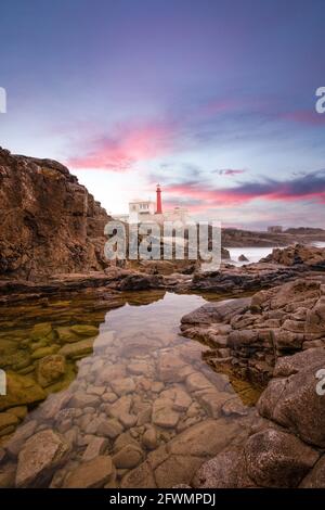 Incredibile faro sulla costa portoghese al tramonto. Foto Stock