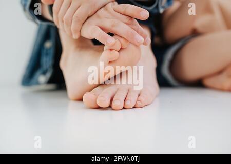 Le mani e i piedi dei bambini si avvicinano. Con unghie leggermente sopravite ma pulite. Foto Stock