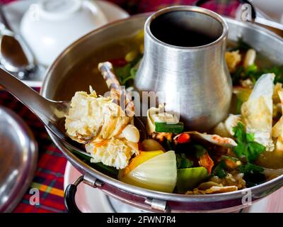 Aragosta Tom Yum. Zuppa speziata di ingredienti tradizionali thailandesi in Thailandia, servita in hot pot. Delizioso pesce in stile tailandese. Foto Stock