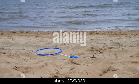 vista su una racchetta di badminton adagiata su una spiaggia di sabbia Foto Stock