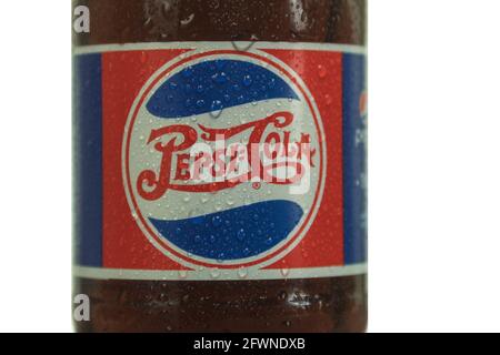 Varsavia, Polonia - 19 maggio 2021: Bottiglia di Pepsi - Cola in vetro con una bevanda fresca. Sfondo bianco isolato. Flacone di pepsi sfocato su fondo scuro w Foto Stock