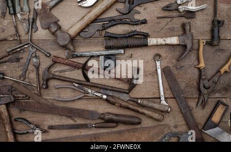 Collezione di antichi utensili a mano per la lavorazione del legno su un banco di lavoro grezzo vecchio legno Foto Stock