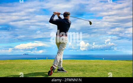 Golfista sul campo da golf professionale. Golfer con il randello di golf che colpisce la sfera per il colpo perfetto. Foto Stock