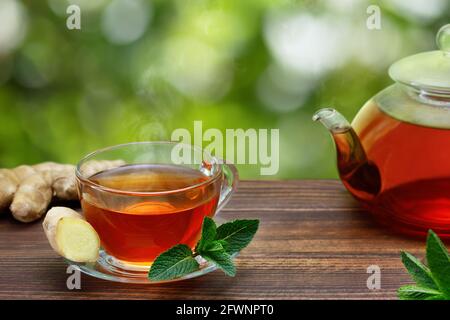 tè caldo con zenzero e menta in una tazza di vetro Foto Stock