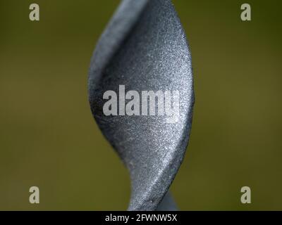 recinzione barra di ferro ritorto macro primo piano dettaglio isolato su sfondo verde Foto Stock