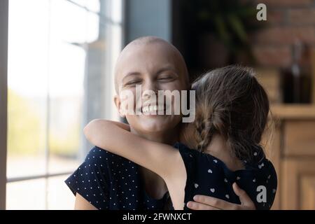 La giovane madre con il cancro ha abbracciato la ragazza della figlia Foto Stock