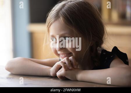 Felice cute prima ragazza teen seduta al tavolo della cucina Foto Stock