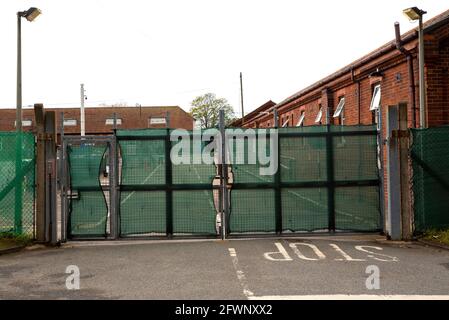 Dal settembre 2020, ex MOD Napier Barracks, Folkestone, sono state utilizzate dall'ufficio di casa per fornire alloggio temporaneo per i rifugiati maschi adulti che cercano asilo nel Regno Unito. Il campo è gestito da Clearspring Ready Homes. In precedenza, circa il 25% dei rifugiati nei campi ha dato risultati positivi per Covid-19, a causa di una grave mancanza di agevolazioni per le distanze sociali. Le caserme sono state dichiarate inadatte all'alloggio umano anche da ispettori indipendenti. L'alta recinzione intorno alle baracche di Napier è sormontata da filo spinato. Nella foto, ingresso alla caserma di Napier. Foto Stock