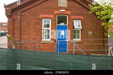 Dal settembre 2020, ex MOD Napier Barracks, Folkestone, sono state utilizzate dall'ufficio di casa per fornire alloggio temporaneo per i rifugiati maschi adulti che cercano asilo nel Regno Unito. Il campo è gestito da Clearspring Ready Homes. In precedenza, circa il 25% dei rifugiati nei campi ha dato risultati positivi per Covid-19, a causa di una grave mancanza di agevolazioni per le distanze sociali. Le caserme sono state dichiarate inadatte all'alloggio umano anche da ispettori indipendenti. L'alta recinzione intorno alle baracche di Napier è sormontata da filo spinato. Nella foto, Napier Barracks alloggio blocco 5. Foto Stock