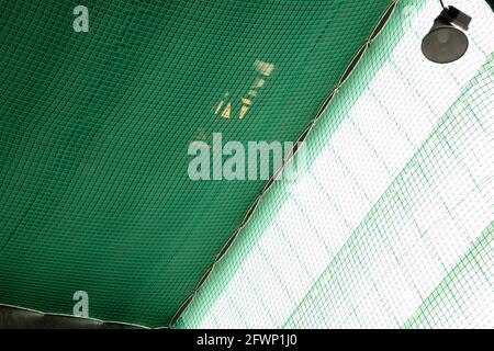 una rete di sicurezza di colore verde, posta sotto il tetto per evitare il rischio di cadute durante i lavori Foto Stock