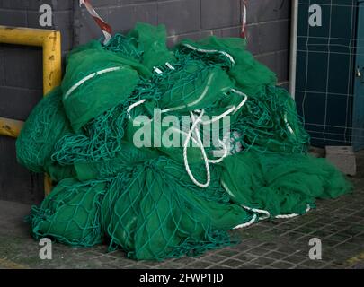 una rete di sicurezza normativa di colore verde, posta sul pavimento pronta per essere utilizzata per evitare il rischio di cadute durante i lavori Foto Stock