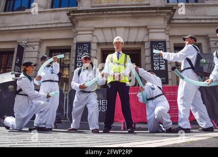 Londra, Regno Unito. 19 maggio 2021. Un protetore della ribellione dell'estinzione vestita come dirigente della Shell e come "Greenwash Busters" fuori dal Museo della Scienza di South Kensington. Manifestanti e scienziati si sono riuniti sia all'interno che all'esterno del museo per dimostrare contro la sponsorizzazione del gigante petrolifero Shell della mostra Our Future Planet Climate Change. Foto Stock