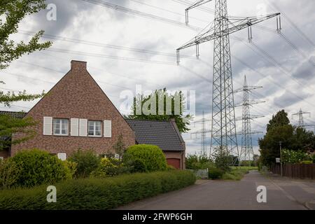 Linee elettriche ad alta tensione su edifici residenziali a Colonia-Weiden, Nord Reno-Westfalia, Germania. Hochspannungsleitungen ueber Wohnhaus a Koeln Foto Stock