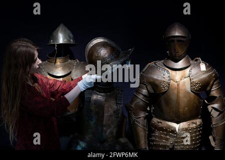 Un dipendente di Bonhams con una selezione di armature, durante un'anteprima del prossimo Antique Arms and Armor sale, al Bonhams' London. Data immagine: Lunedì 24 maggio 2021. Foto Stock