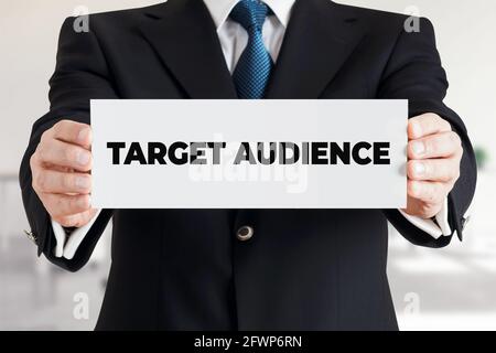 L'uomo d'affari mostra un banner con il pubblico di destinazione del messaggio. Concetto di marketing aziendale. Foto Stock
