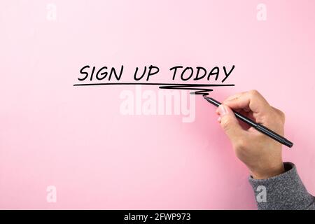 Mano che scrive un SEGNO di parola OGGI su sfondo rosa. Foto Stock