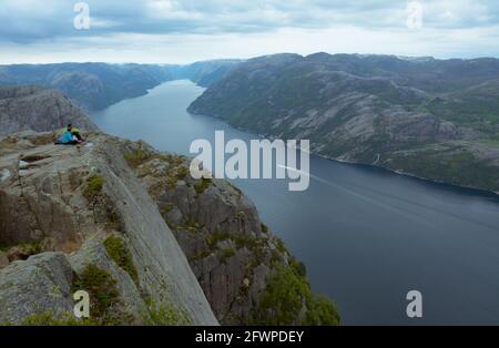 Rogaland, Norvegia - 23 maggio 2017: Una coppia gode di una splendida vista del Lysefjord in una giornata trascorsa dalla roccia Pulpit, Norvegia. Chiamato anche P Foto Stock